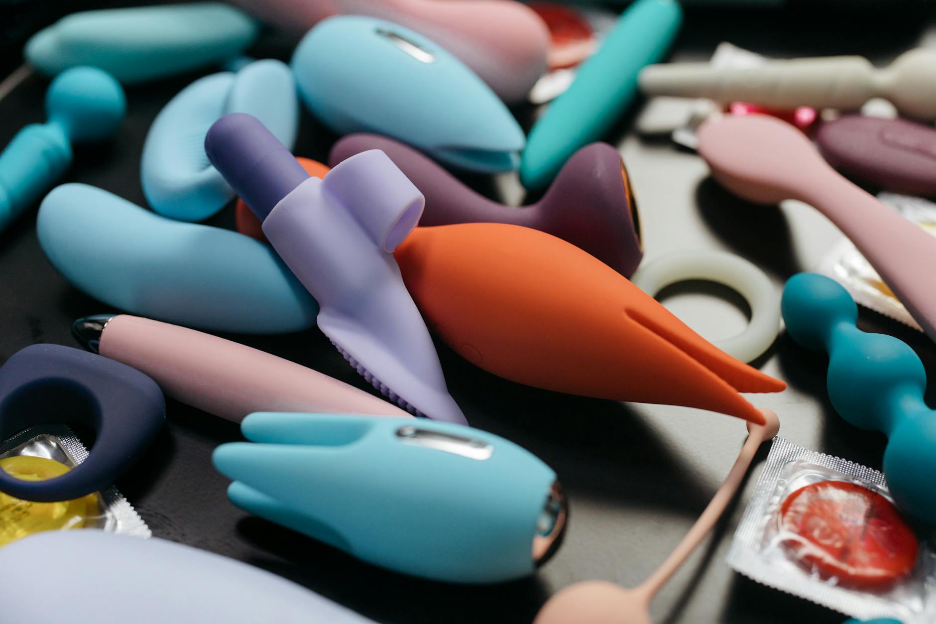 Mano sosteniendo vibrador azul contra fondo púrpura
