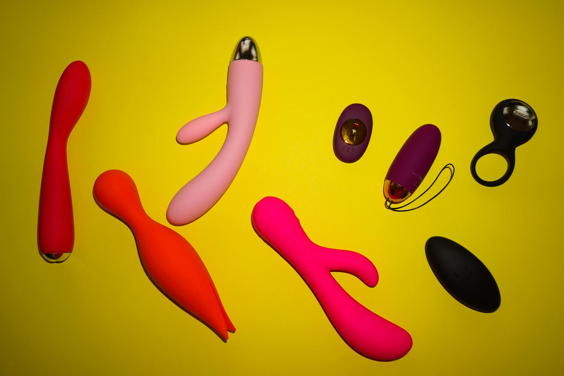 Manos íntimas sosteniendo un vibrador azul brillante contra fondo púrpura