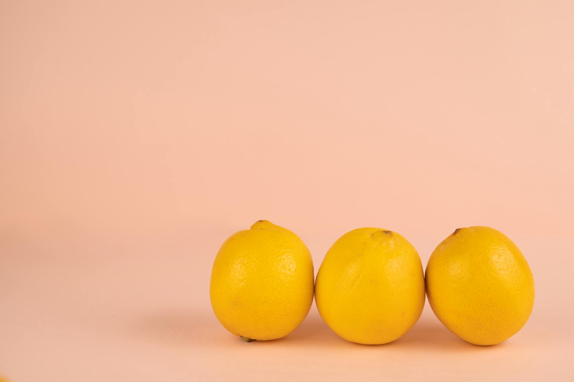 Vibradores de limón junto a limones frescos en fondo pastel, simbolizando la sensibilidad renovada