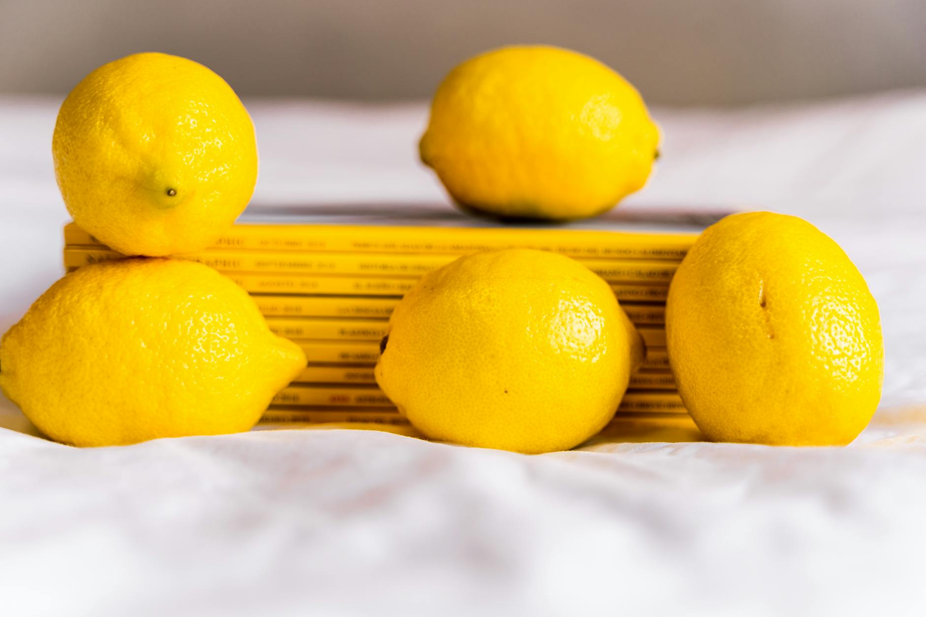 Limones brillantes maduros con tallos sobre fondo pastel, representando el vibradores de limón para principiantes